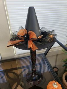 a lamp that is sitting on top of a glass table with pumpkins in the background