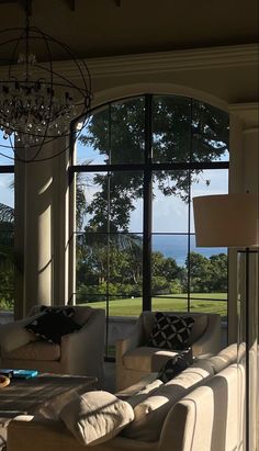 a living room filled with furniture and large windows