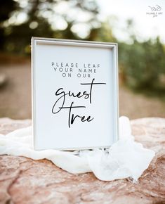 a sign that says please leave your name on our guest tree in front of some rocks