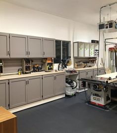 a workbench in a large room with lots of cabinets and tools on it