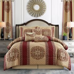 a bed in a bedroom with red and beige comforter set on it's side