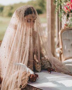 a woman wearing a veil sitting on top of a bed