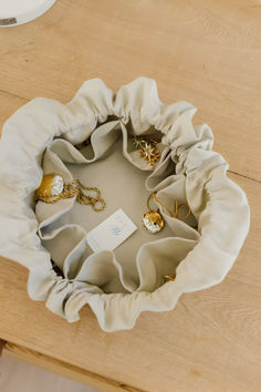 a wooden table topped with lots of different items on top of each other and a white cloth bag in the middle