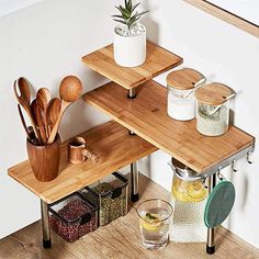 three tiered wooden table with utensils and other kitchen items on it in the corner