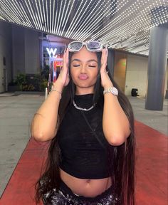 a woman with long hair and sunglasses on top of her head is posing for the camera