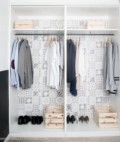 an organized closet with clothes and shoes hanging on the wall, along with wooden crates