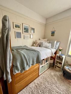 a bedroom with a bed, rug and pictures on the wall