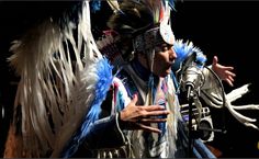 a man dressed in native american clothing with feathers on his head