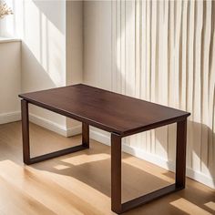 a wooden table sitting on top of a hard wood floor next to a white wall