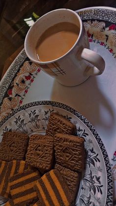 some cookies are on a plate next to a cup of coffee