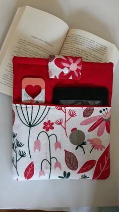 an open book sitting on top of a table next to a red case filled with books