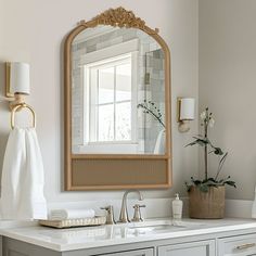 a bathroom sink with a mirror above it and towels hanging on the wall next to it