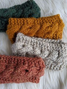 four crocheted headbands laying on top of a white furnishing