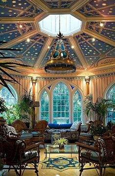 a living room filled with lots of furniture under a domed ceiling mounted chandelier