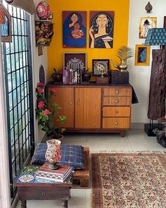 a living room filled with furniture and paintings on the wall above it's windows