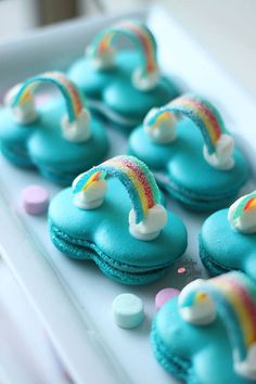 some little blue cookies with rainbow decorations on them and the caption says sweetychicshelevents