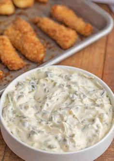 a white bowl filled with dip next to some fried chicken