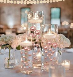 the centerpieces are filled with candles, flowers and glass vases for an elegant touch