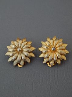 "KRAMER Gold Poinsettia Earrings Clip-Ons, Gold Flower Earrings, Gold Tone Gardenia Flower Clip-Ons Kramer, Vintage Christmas ♥ Gorgeous and highly collectible signed KRAMER clip-on earrings featuring very detailed textured gold tone Poinsettia flowers. Hallmarked: KRAMER©. Earrings measure approx. 1\" in diameter. Very good condition with a chip to the gold plate in the center of one flower, not noticeable when worn. These beautiful vintage earrings will make a great addition to your collection Gardenia Flowers, Poinsettia Earrings, Gardenia Flower, Mid Century Earrings, Gold Flower Earrings, Clear Crystal Earrings, Gold Round Earrings, Flower Earrings Gold, Poinsettia Flowers