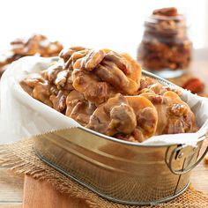 a metal bowl filled with nuts on top of a wooden table