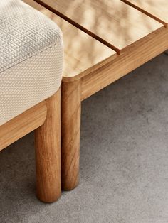 a close up of a wooden table with a white cushion on the top and bottom