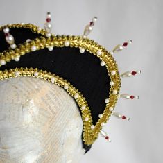 This royal Tudors inspired attifet headdress will make an excellent addition to your historical costume. It is covered with black silk shantung and embellished with golden braided trimming all around the edges.This unique piece wouldn't be complete without all those wonderful pearl bead details that add some royal flair to it's elegance. Choose between only pearl decoration or a combination of pearl beads and small red crystals to add just a pop of color. The headpiece is very light and comforta Traditional Fitted Headpiece For Costume, Traditional Wedding Hat With Structured Crown, Elegant Costume Hat With Pinched Crown, Elegant Costume Hats And Headpieces With Pinched Crown, Elegant Costume Hats With Pinched Crown, Adjustable Ceremonial Costume Hat With Structured Crown, Handmade Costume Headpiece, Fitted Tall Crown Headpiece For Costume Party, Traditional Fitted Headpiece For Festivals