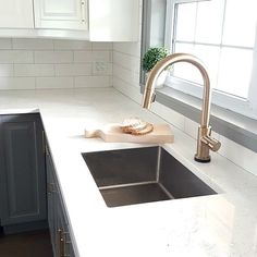 a kitchen sink with a cutting board on the counter