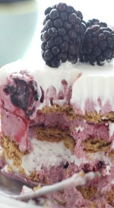 a close up of a cake on a plate with berries and ice cream frosting