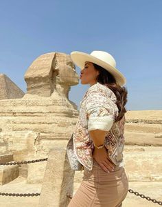 a woman standing in front of the sphinx at giza