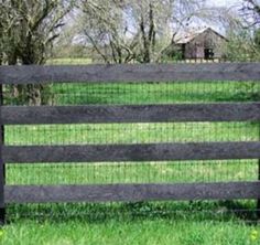 a black fence in front of a grassy field