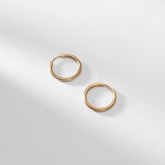 These beautifully simple hoops are versatile enough to wear with any outfit. Made from gold stainless steel, they feature a backless closure to form a complete circle. Small Hoop Earrings In Yellow Gold Stainless Steel, Minimalist Metal Round Huggie Earrings, Minimalist Round Metal Huggie Earrings, Small Yellow Gold Hoop Earrings In Stainless Steel, Small Yellow Gold Stainless Steel Hoop Earrings, Everyday Yellow Gold Stainless Steel Hoop Earrings, Elegant Everyday Circle Huggie Earrings, Minimalist Stainless Steel Hoop Earrings For Everyday, Minimalist Tarnish Resistant Round Hoop Earrings