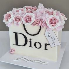 a white bag with pink roses on it and a tag that says dior in black lettering