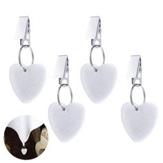 three pairs of heart shaped earrings hanging from hooks on a white background with an image of a woman's face