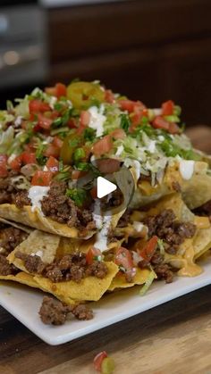 nachos with meat and vegetables on a white plate