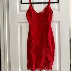 a red dress hanging on a white door with a hanger in front of it