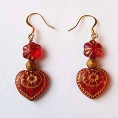 "Red hearts and flowers are Valentine's Day classics, but these dangle earrings elevate the classic combination to new levels with beautiful old world styling. The romantic vintage style makes them a perfect gift for bohemian poets, artists, and lovers....the rich red heart and flower beads delight the eyes and brushed gold highlights bring forth the many details that make these earrings so special. The length of these earrings is a little under 2.25\" (about 5.5 cm) including the ear wires.  These one of a kind (OOAK) earrings come carded & wrapped in tissue paper. That's right, there is only one pair or these earrings! Most of my supplies are bought in very limited quantities, so I only make one of each item unless otherwise noted. SAVE ON SHIPPING--Many items in my shop ship for free wh Red Vintage Heart Earrings For Gifting, Vintage Red Heart Earrings For Gift, Red Vintage Heart Earrings For Gift, Vintage Red Heart Earrings As Gift, Red Dangle Flower Earrings For Valentine's Day, Vintage Red Heart Earrings For Pierced Ears, Red Vintage Heart Earrings, Red Hypoallergenic Flower Earrings For Gift, Red Vintage Earrings For Valentine's Day