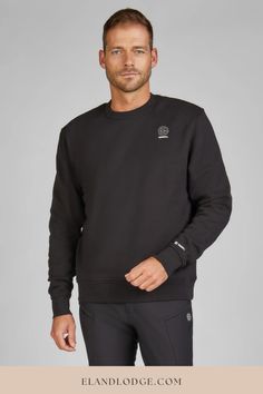 a man wearing a black sweatshirt and pants