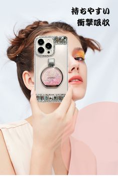 a woman holding up a cell phone to her face and looking into the camera with glitter eyeshadow