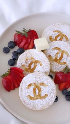 three pastries on a plate with strawberries and blueberries