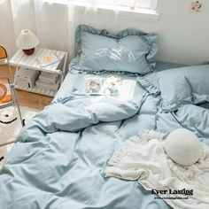 a bed with blue sheets and pillows in a bedroom