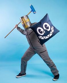 a man dressed as a cartoon character holding a blue pillow with a face on it