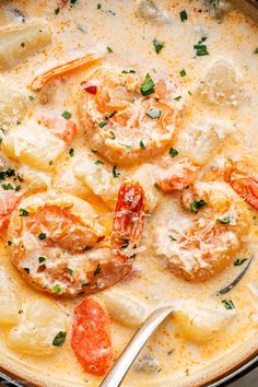 a bowl filled with shrimp and grits next to a spoon