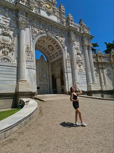 a woman standing in front of an ornate building