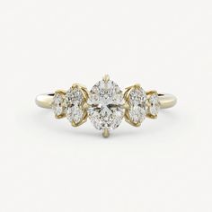 a gold ring with three pear shaped diamonds on top and two smaller pears in the middle