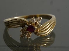 This beautiful Vintage late 1970's - early 1980's split semi bypass Ruby and Diamond ring is the perfect birthday gift for July or anyone who loves Rubies. Item Specifics Weight: 2 Grams Metal: 14k Yellow Gold Stones: .08 ct Natural Ruby, 6 .025ct Natural Diamonds The table of the top stone sits 4.57mm above the finger Ruby Ring Vintage Gold, Gold Ring With Ruby Stone, 1980s Engagement Ring, 60s Engagement Ring, Vintage Ring For Birthday, Vintage Style Bypass Ring As Gift, Vintage Rings Antiques, Vintage Ruby Ring, Ruby Engagement Ring Vintage