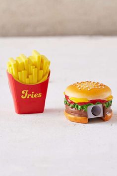 a toy hamburger and french fries sitting next to each other on a white countertop