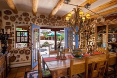 the dining room table is surrounded by many plates and pans on display in front of an open glass door