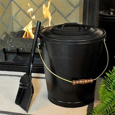 a bucket and shovel sitting on the floor next to a fire place