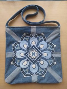 a blue purse with a flower design on it