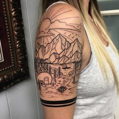 a woman with a mountain scene tattoo on her arm